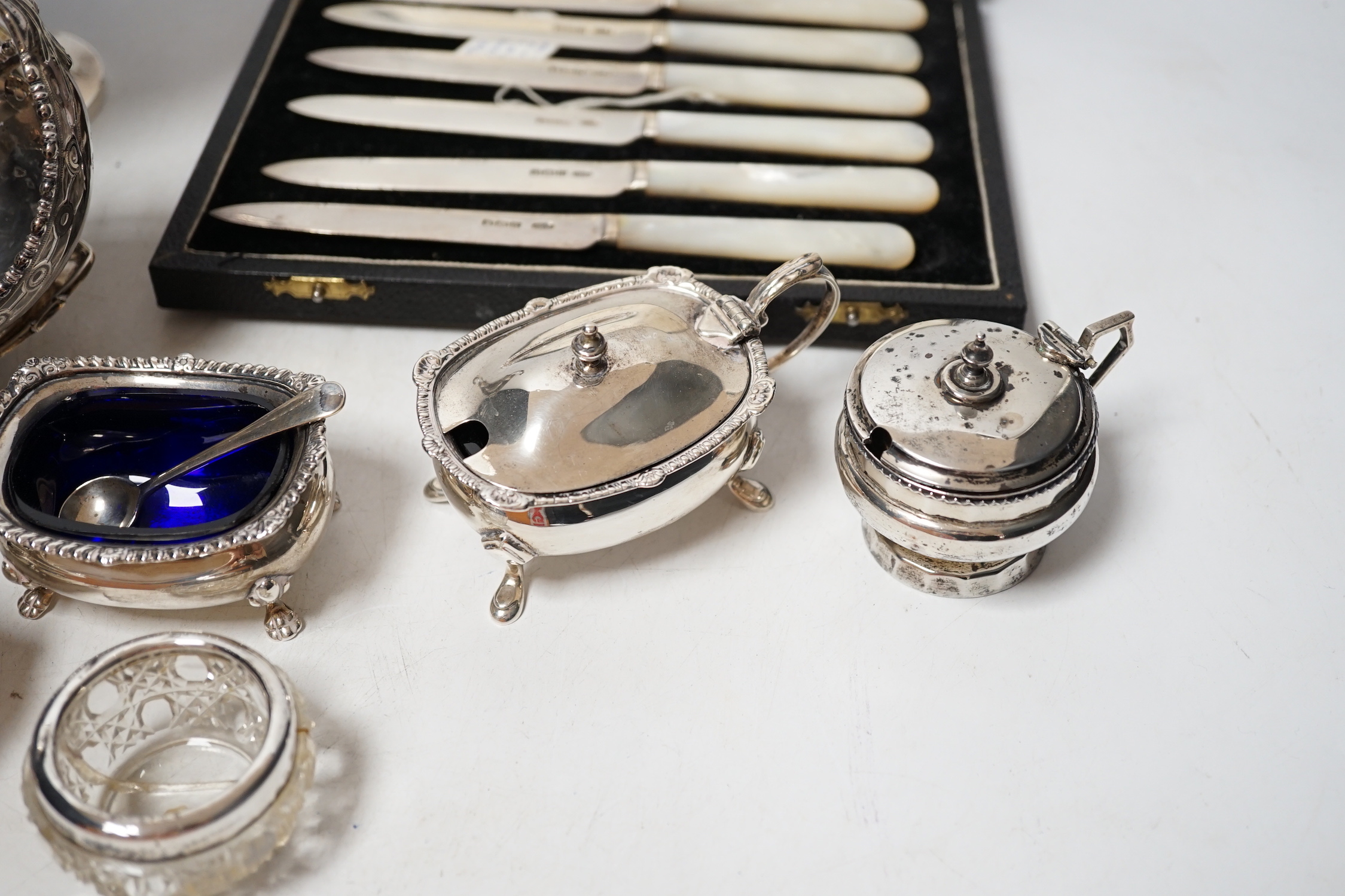 An Edwardian small silver two handled pedestal dish, London, 1902, height 12cm, a silver inkstand base, a silver boat shaped dish (lacking stand), a pair of silver salts with blue glass liners and spoons, three other sil